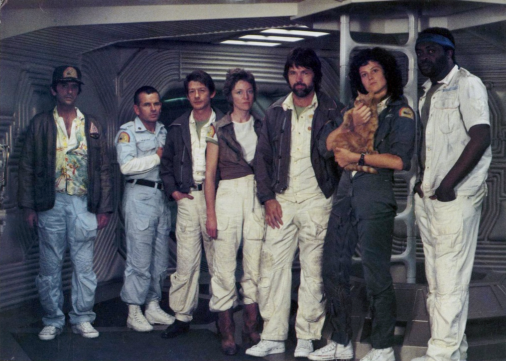 Da esquerda para a direita: Brett (Harry Dean Stanton), o técnico de engenharia; Ash (Ian Holm), o oficial de ciência; Kane (John Hurt) o oficial executivo; Lambert (Veronica Cartwright), a navegadora; Dallas (Tom Skerritt), o capitão; Ripley (Sigourney Weaver) a subtenente; Jones, o gato; Yaphet Kotto (Parker), o engenheiro.